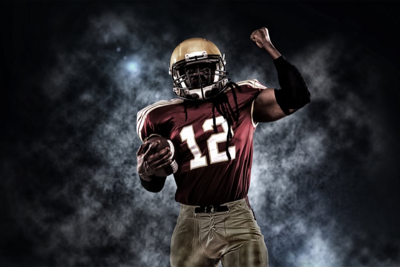 Proud American football player against a dark background