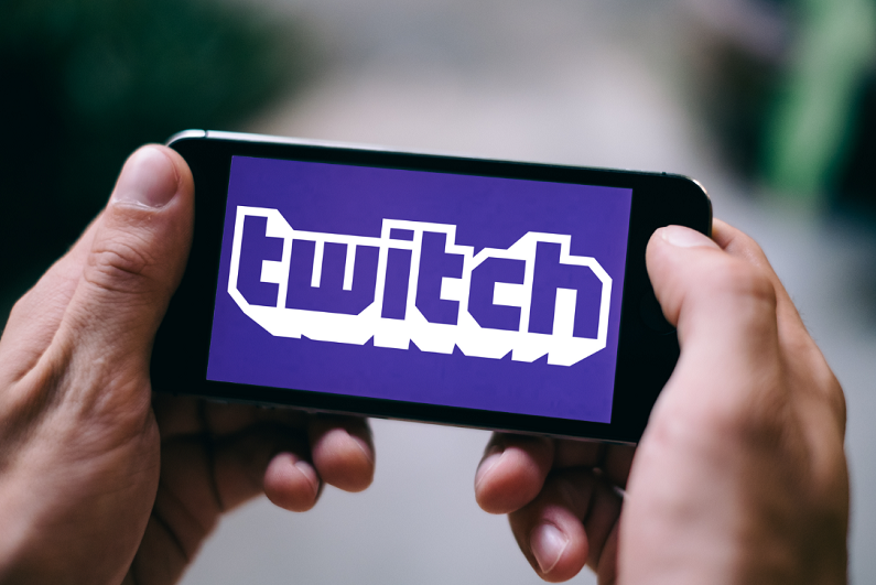 male holding iPhone displaying Twitch logo