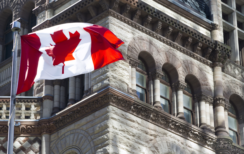 flag of Canada against grey-stone building background