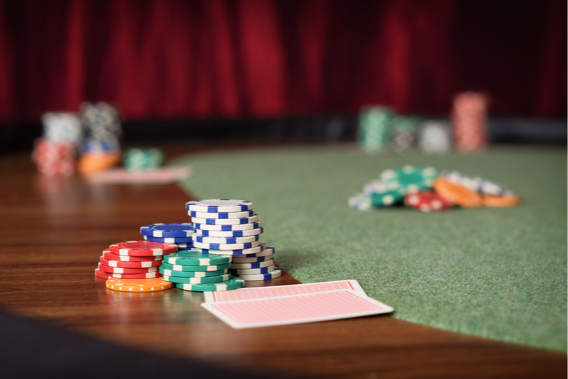 Table-level view of poker table with chip stacks and cards