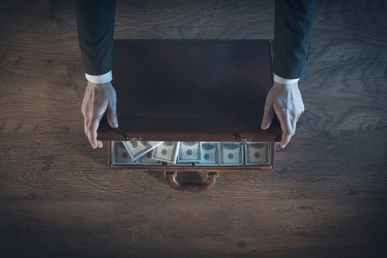 man opening briefcase full of money