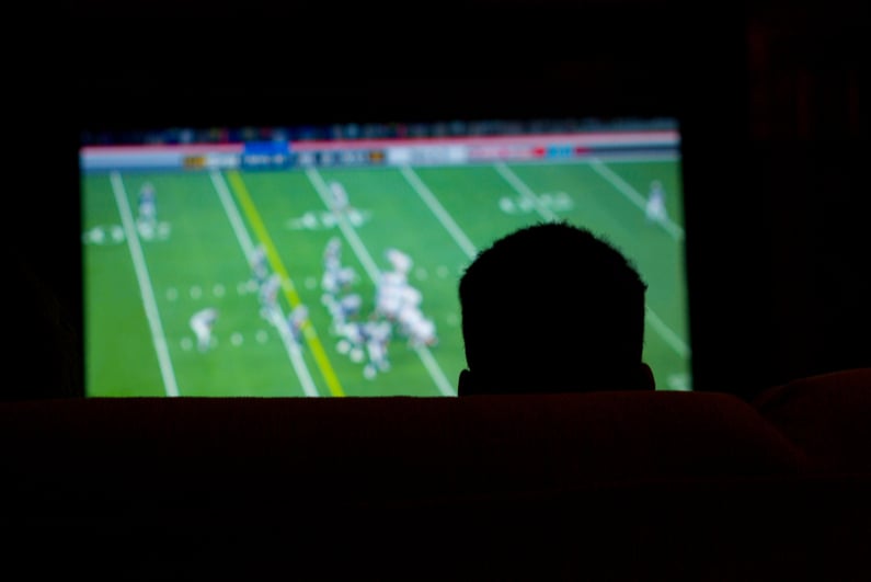 Silhouette of man watching football